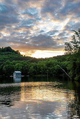 Sunset Photograph - Small Boathouse By A Lake During Sunset by John Twynam