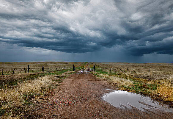 Landscape Photograph - Storm Clouds Over Rural Dirt Road And Gate On The Prairie by Robert Niemeier
