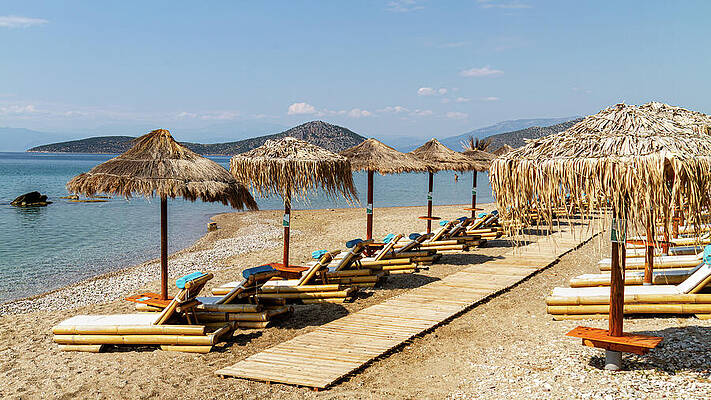 Sunny Beach with Straw Umbrellas Photograph
