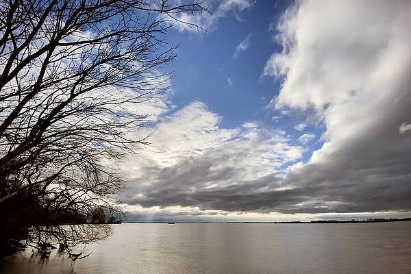 Serene Wall Art featuring the photograph Tranquil Reflections A Serene Canvas Beneath The Dramatic Sky by Travel Essayist