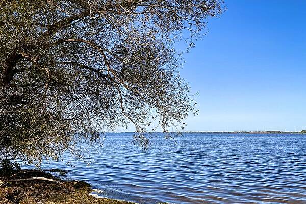 Serene Wall Art featuring the photograph Tranquil Reflections Serene Lakeside Beauty Under A Clear Sky by Travel Essayist