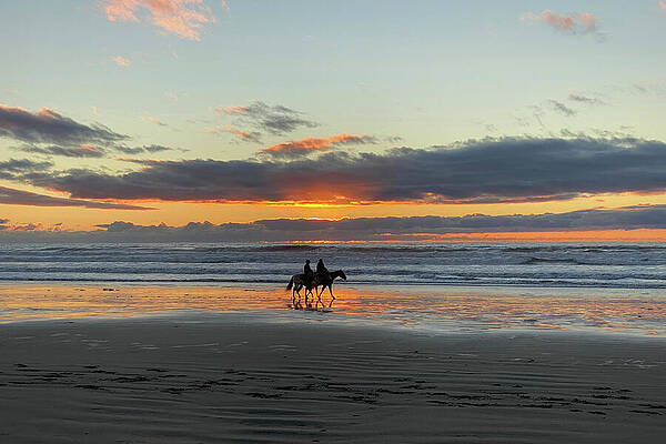 Wall Art featuring the photograph Two Horseback Riders On The Beach At Sunset by Matthew DeGrushe
