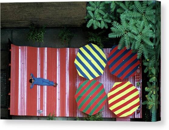 A Patio With Striped Umbrellas Canvas Art Print by James Mathews