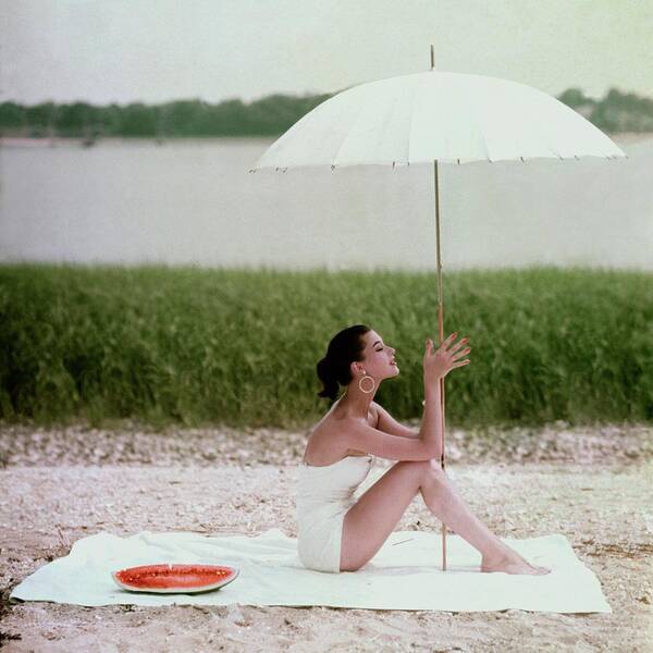 Woman Relaxing Under a Beach Umbrella Poster