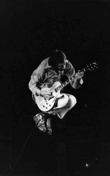 Iconic guitarist mid-jump on stage Wall Art
