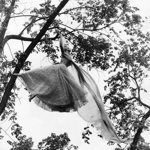 A Model Wearing A Dress In A Tree by Gene Moore A Model Wearing A Dress In A Tree by Gene Moore