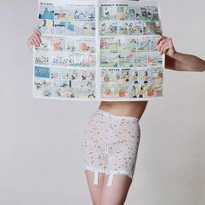 A Model Wearing A Girdle With A Comic by Louis Faurer