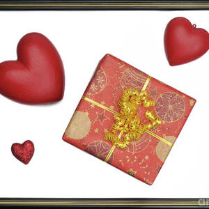 Gift box and heart-shaped objects in picture frame by Sami Sarkis Photography