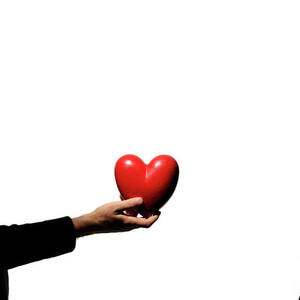 Silhouette of couple standing face to face man holding heartshaped object by Sami Sarkis Photography