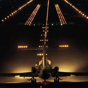 Airplane On Runway At Night by Comstock