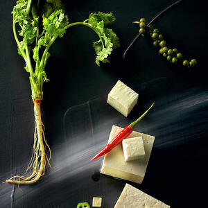 Food Art: Tofu With Coriander, Chilli And Pepper On A Black Surface by Manfred Rave