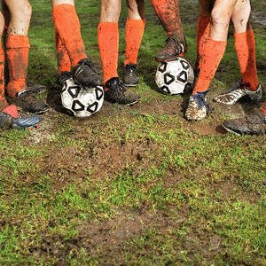 Muddy Legs Of Soccer Players by Jupiterimages