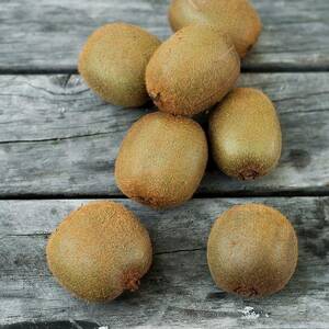 Several Kiwi Fruit On A Wooden Surface by Sarka Babicka