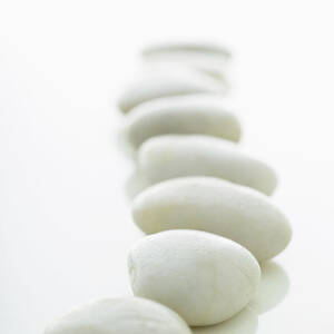 White Stones Lined Up On A White by Rick Lew