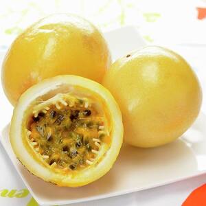 Yellow Passion Fruit, Whole And Cut In Half by Alain Caste