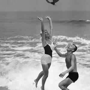 Young Couple Playing With Beach Ball At by Stockbyte